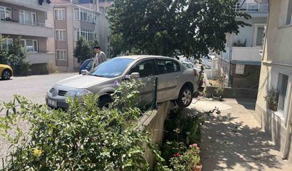El frenini çekmeyi unuttu, otomobil bahçe duvarında asılı kaldı