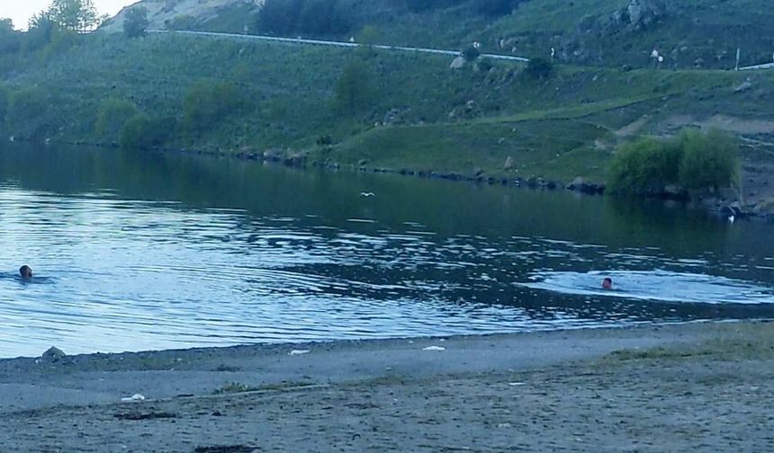 Sıcaktan bunalan gençler Çıldır Gölü'nde serinliyor